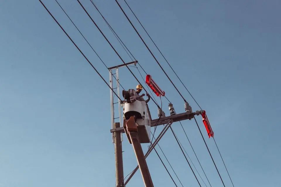 Worker on Hoist Repairing Power Line