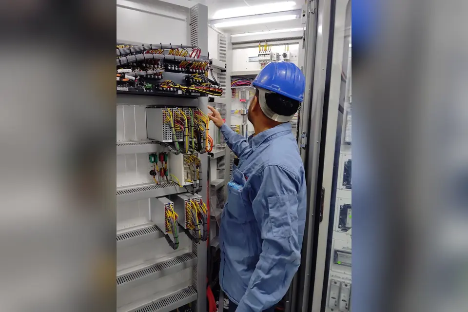 Electrician in Helmet Working with Cables