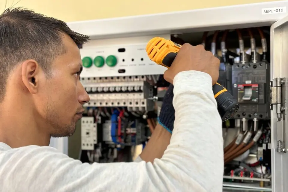 A man is working on an electrical panel