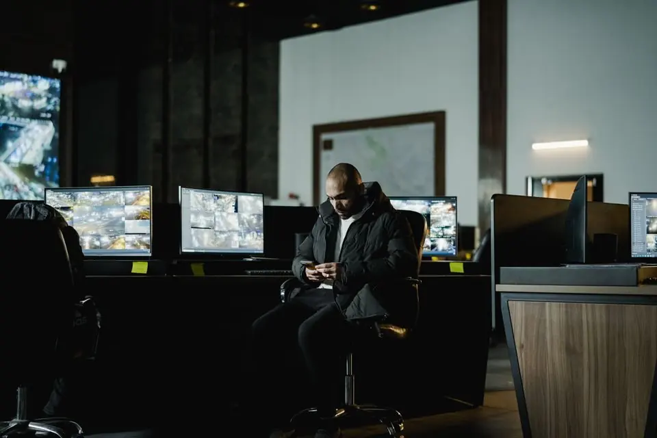Security Officer in Dark Control Room with Monitors