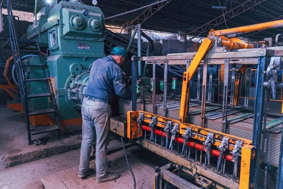 Worker Operating Machinery in Industrial Factory
