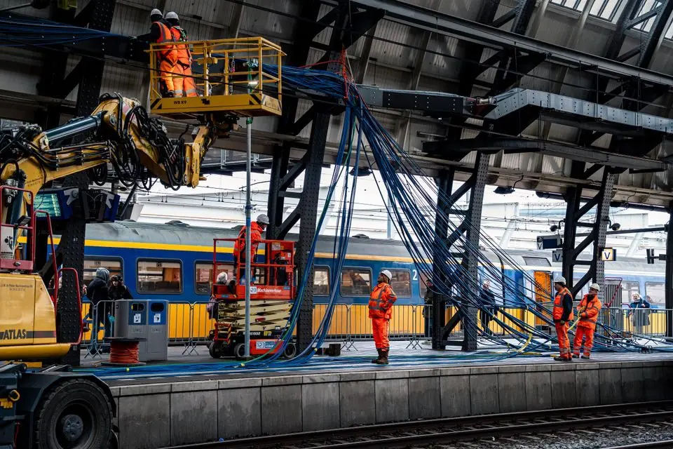 Construction Workers Installing Cables at Train Station